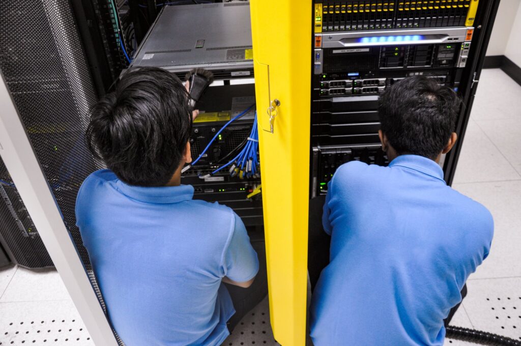 Professionals cleaning a data center server.