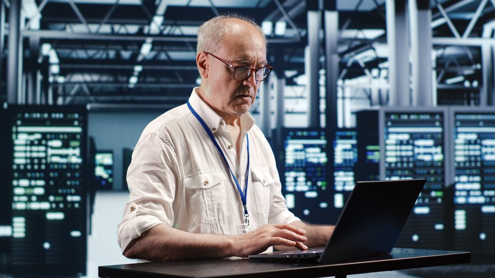 Data center disaster recovery consultant reviewing contamination assessment reports inside a server room after a critical environment incident.